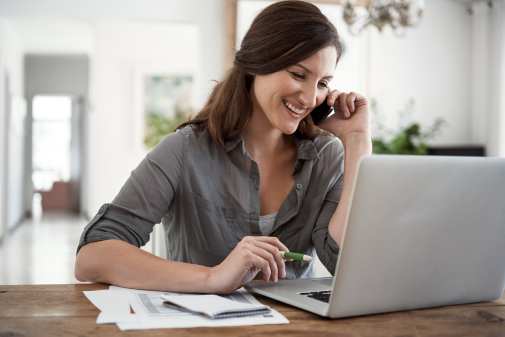 woman talking on the phone whilte working on computer