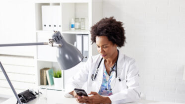 Doctor woman type text on mobile phone